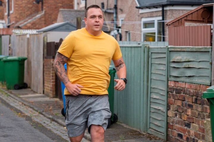 Man running next to houses