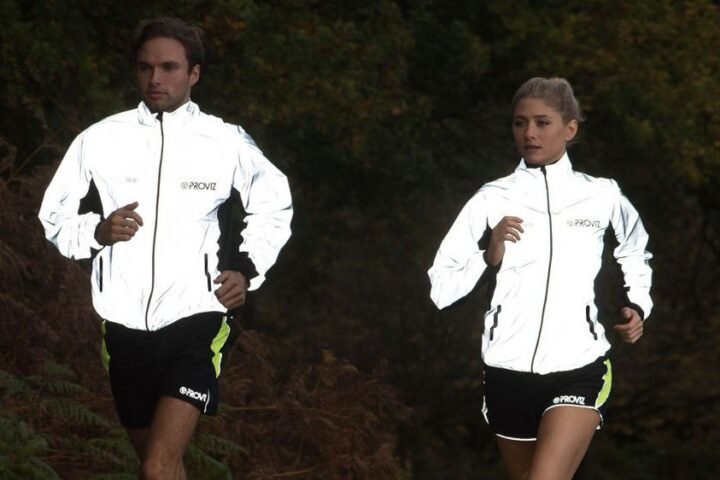 Man and woman running in reflective Proviz jackets