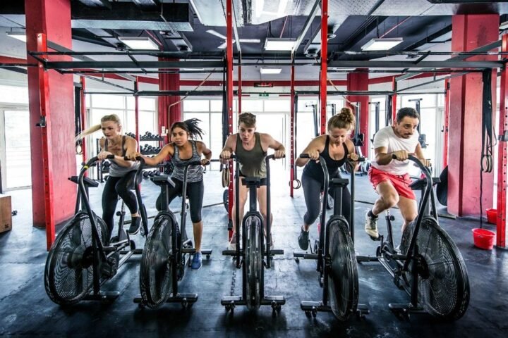 Group of people riding exercise bikes in a gym