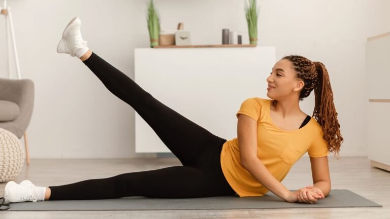 Woman lies on her side with one leg raised